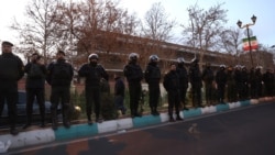 Members of the Iranian police stand guard at a protest in front of the British Embassy in Tehran on January 14.