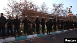 Припадници на иранската полиција чуваат стража на протест пред британската амбасада во Техеран, 14 јануари.