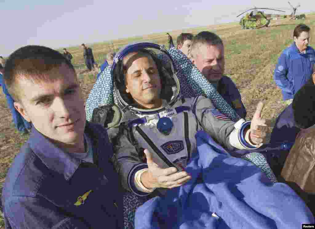 Acaba soaks up the sun shortly after he is removed from the Soyuz capsule. &quot;It&#39;s good to be home,&quot; he said.