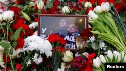 Fotografija ruskog opozicionog političara Alekseja Navaljnog i njegove supruge Julije postavljena među cveće na njegov grob nakon sahrane na Borisovskom groblju u Moskvi 2. marta 2024.