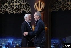 Kandidati reformist, Masud Pezeshkian, dhe konservatori i linjës së ashpër dhe ish-negociatori për çështje bërthamore, Saeed Jalili, duke u përshëndetur pas një debati zgjedhor në teelvizionin shtetëror të Iranit më 1 korrik.