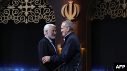 Hard-line presidential candidate Saeed Jalili (left) shakes hands with reformist hopeful Masud Pezeshkian after a televised debate on July 1.
