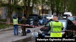 Поліцейські стоять поруч із тілами на місці стрілянини в Києві, Україна, 18 квітня 2026 року