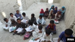 Pupils in the Kuchu village in southeastern province of Sistan and Baluchistan study in a ruined building.