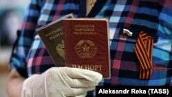Жінка тримає паспорт Росії та документ, наданий угрупованням «ЛНР», під час голосування за конситуційну реформу в Росії, червень 2020 року
