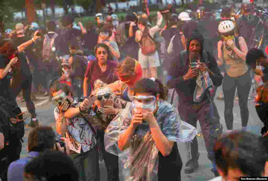 Протестувальники тікають від поліції під час сутички, коли та використала перцеві аерозолі проти протестувальників, які намагалися знести пам&rsquo;ятник президентові США Ендрю Джексонові в центрі парку Лафаєт. Вашингтон, округ Колумбія, США