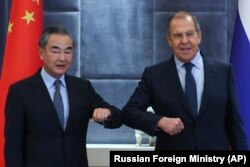 Chinese Foreign Minister Wang Yi (left) and Russian Foreign Minister Sergei Lavrov greet each other on the sidelines of a meeting of the Collective Security Treaty Organization in Dushanbe in September.