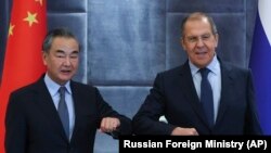 Chinese Foreign Minister Wang Yi (left) and Russian Foreign Minister Sergei Lavrov greet each other during their meeting on the sidelines of a meeting in Dushanbe in 2021.