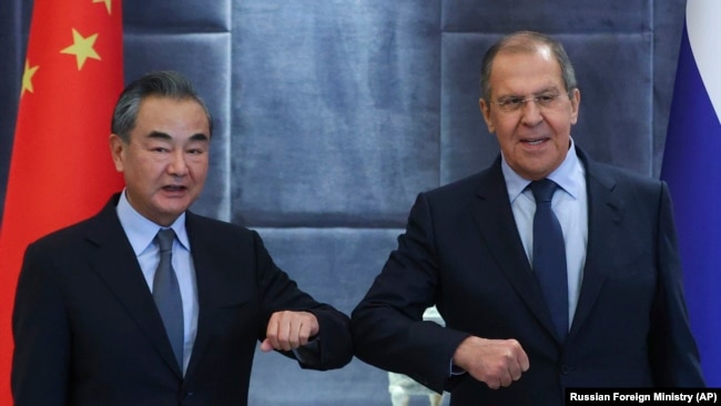 Ministrul chinez de externe Wang Yi (stânga) și ministrul rus de externe Serghei Lavrov se salută la reuniunea Organizației Tratatului de Securitate Colectivă la Dușanbe, în septembrie.