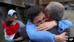 Ethnic Armenians who fled Nagorno-Karabakh embrace upon their arrival in Kornidzor, in Armenia's Syunik region, on September 26.