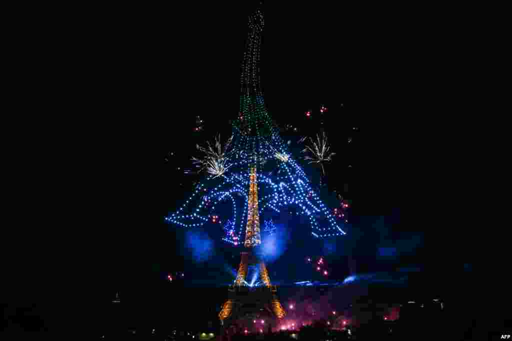 Artificiile și dronele luminează cerul din jurul Turnului Eiffel în cadrul unui spectacol coregrafic organizat cu ocazia Zilei Bastiliei la Paris, pe 13 iulie 2026, în ajunul paradei anuale.