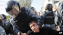 Riot police detain a demonstrator during a protest against the pilgrimage of Hassidic Jews in the town of Uman.