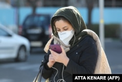 테헤란에서 한 이란 여성이 스마트폰으로 메시지를 확인하고 있다.  