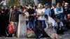 Macedonia -- People, part of a new group of more than a thousand immigrants, gather near a Yugoslavia border stone, as they wait at the border line of Macedonia and Greece to enter into Macedonia near Gevgelija railway station, August 20, 2015