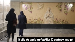 Ирански жени минават край релефна скулптура на Дева Мария на метростанция в Техеран, Иран, 18 октомври 2025 г.