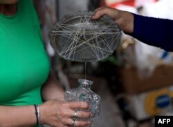 Ariana Nikolla dhe Resmie Tuci duke përgatitur ujin e trëndafilit, sipas mënyrës tradicionale.