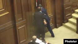 Armenia - Opposition deputy Aghvan Vartanian (L) helps an apparently drunk pro-government colleague, Arayik Grigorian, leave the parliament floor, Yerevan, 22May2014.