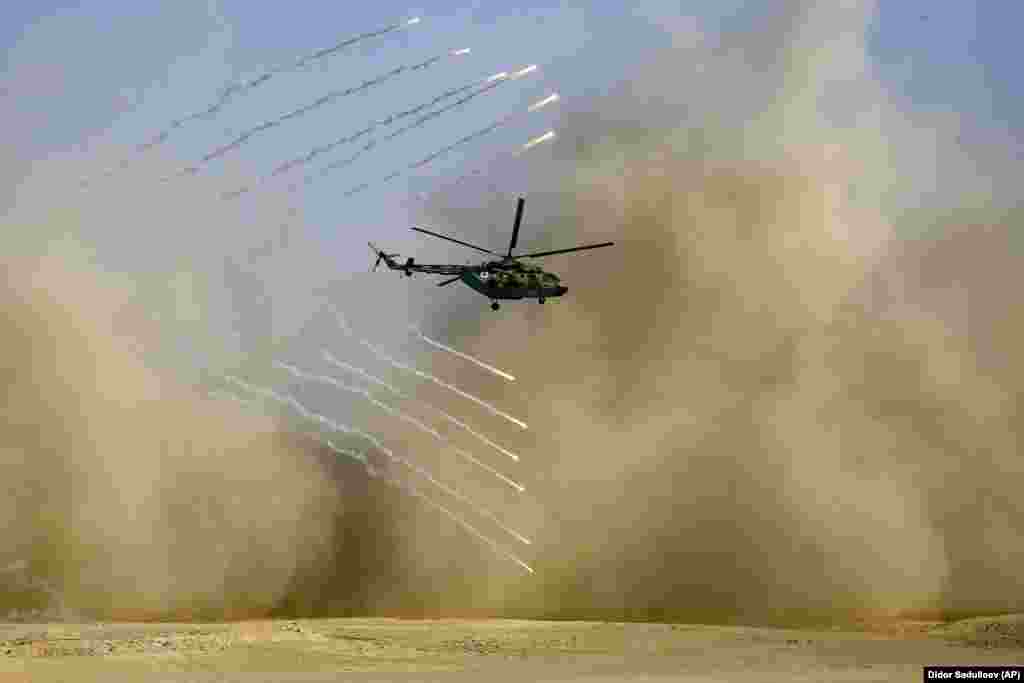 A military helicopter flies during the joint Russian, Tajik, and Uzbek drills at Tajikistan&#39;s Harb-Maidon firing range on August 10.