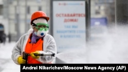 A municipal worker sprays disinfectant on an empty street in Moscow.