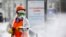 A municipal worker sprays disinfectant on an empty street in Moscow.