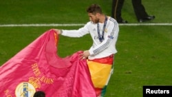 Portugal - Real Madrid's Sergio Ramos performs a bull fight as he celebrates after defeating Atletico Madrid in their Champions League final soccer match at the Luz Stadium in Lisbon May 24, 2014.