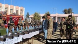 Afghan security officials display weapons and ammunition seized during recent operations against Taliban militants in Helmand on January 26.