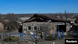 Поліцейський проходить повз пошкоджений будинок у прифронтовому місті Оріхів, Запорізька область, 28 лютого 2024 року