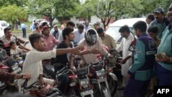 FILE: Pakistani commuters queue for fuel at a Pakistan State Oil (PSO) gas station in July 2017.