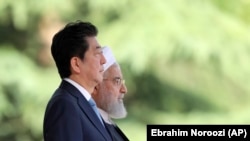 IRAN -- Japanese Prime Minister Shinzo Abe, left, is welcomed by Iranian President Hassan Rohani, during an official arrival ceremony at the Saadabad Palace in Tehran, IJune 12, 2019