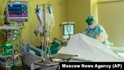 Медик в спецкостюме в одной из московских ковидных госпиталей ухаживает за пациентом, 17 июня 2021 года