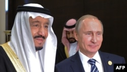 Russian President Vladimir Putin (C) poses with Saudi King Salman bin Abdulaziz Al Saud during a meeting on the sidelines of the G20 summit in Antalya, November 16, 2015