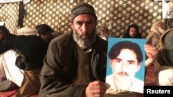 A member of Pakistan's Pashtun community holds a picture of Naqibullah Mehsud, whose extrajudicial killing by Karachi police sparked nationwide protests.