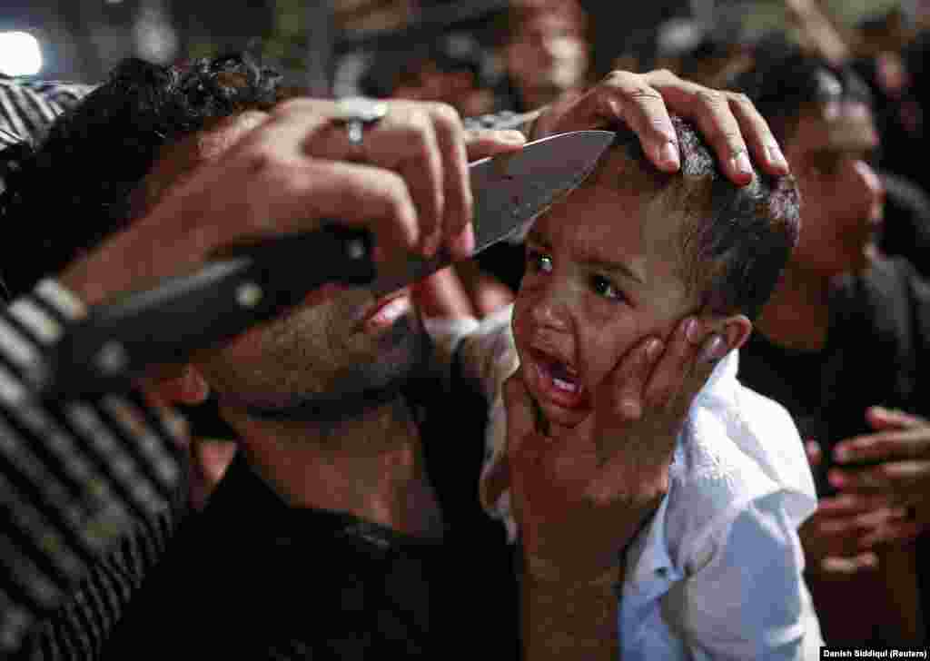 A Shi&#39;ite Muslim has his child gashed with a knife during a religious procession in Mumbai on November 3, 2014.&nbsp;