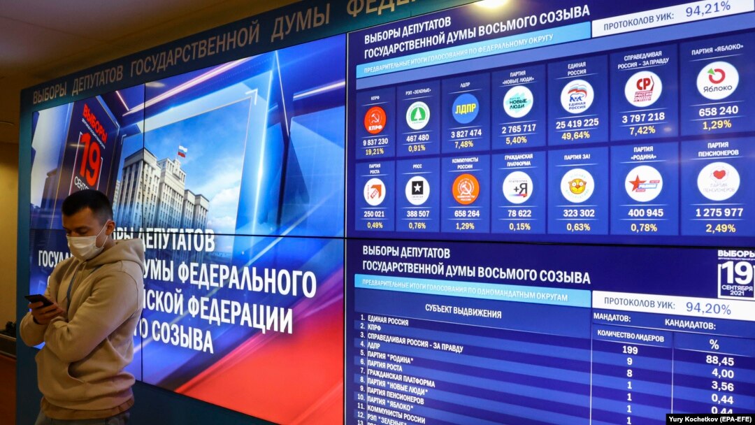 Un bărbat stă cu spatele la ecranele care prezintă rezultatele preliminare ale alegerilor parlamentare din Rusia. Scrutinul s-a desfășurat vreme de trei zile, între 17 și 19 septembrie, și este marcat de grave acuzații de fraudă. 