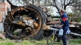 UKRAINE – A local resident looks at a destroyed Russian tank next to a residential house in the village of Mala Rogan, east of Kharkiv, on May 15, 2022