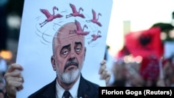 Demonstrant drži transparent s likom albanskog premijera Edija Rame tokom protesta protiv plana za izgradnju luksuznog kompleksa na ekološki osetljivom delu jadranske obale, Tirana, 5. jun 2026.