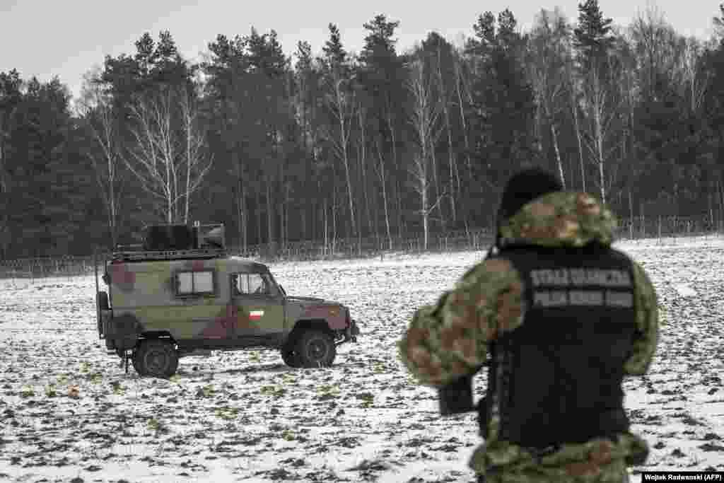 Un polițist de frontieră polonez transmite în 5 limbi diferite prin intermediul difuzoarelor montate pe un vehicul de patrulă că traversarea graniței este interzisă, în timpul unei vizite a jurnaliștilor la graniță, pe 25 ianuarie 2022.