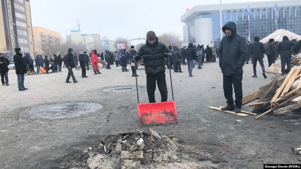 Алаңды тазалап жүрген еріктілер. Ақтөбе, 6 қаңтар 2022 ж.