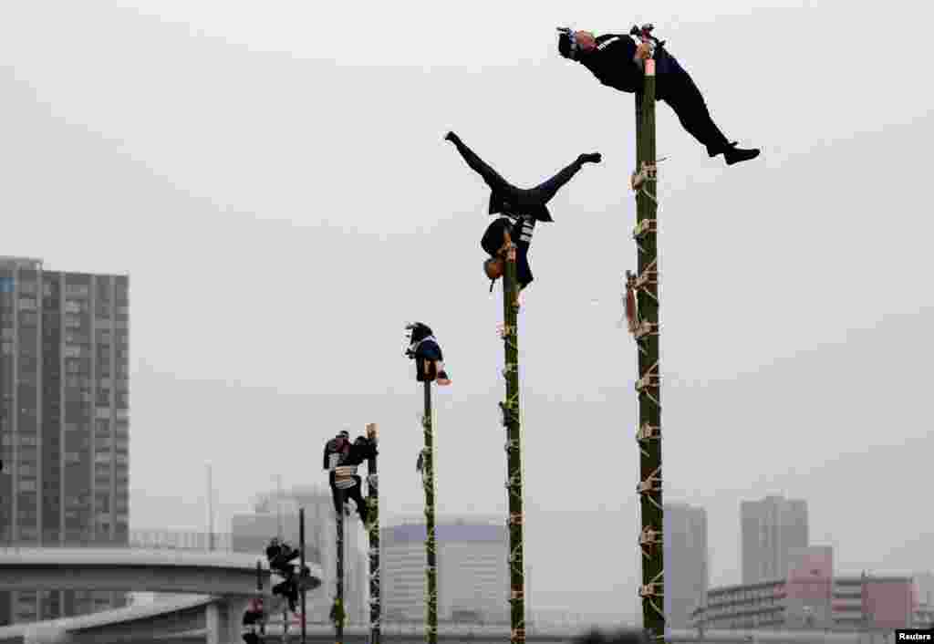 Members of the Edo Firemanship Preservation Association display their balancing skills atop bamboo ladders during a New Year demonstration by the fire brigade in Tokyo, Japan, January 6, 2022