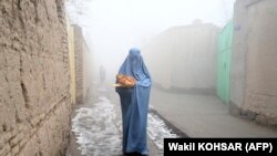 Afganistanka vraća se kući nakon što je dobila besplatan hljeb podijeljen u sklopu kampanje Spasimo Afganistance od gladi, Kabul (18. januar 2022.)