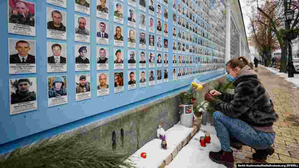 A woman at a memorial wall outside the monastery to men killed fighting Russia-backed separatists in 2014. The photo was made on January 21 during the anniversary of the end of fighting for the Donetsk airport in 2015, and as fears mount that an all-out invasion of Ukraine by Russia may be imminent.&nbsp;