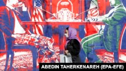 Илусатрација, Иранска жена поминува покрај анти САД плакат на ѕидот на поранешната американска амбасада во Техеран 