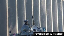 Казахский военный в бронеавтомобиле у здания горадминистрации, которое было подожжено во время недавних акций протеста, Алматы, 12 января