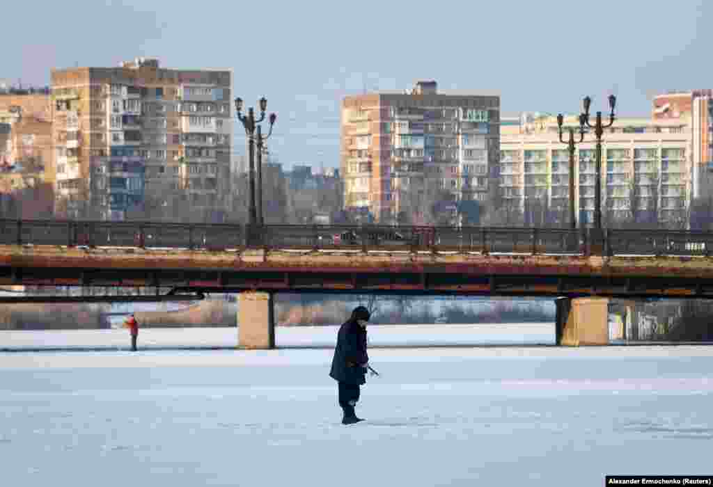 Чоловік ловить рибу на вкритій льодом річці Кальміус в окупованому Донецьку. 26 січня 2022 року