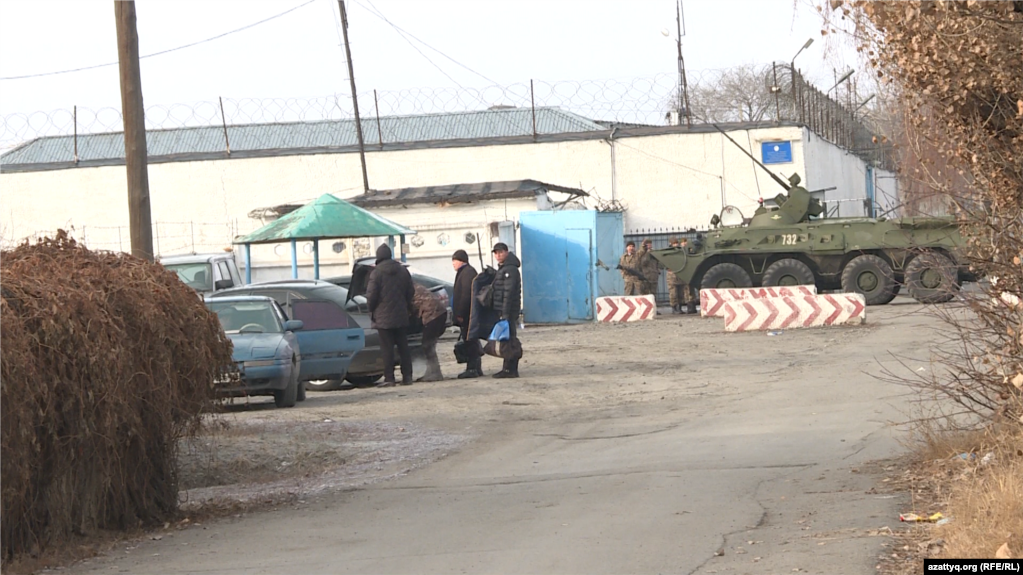 Гражданские, военные и бронетранспортер возле следственного изолятора в городе Талдыкоргане. 12 января 2022 года