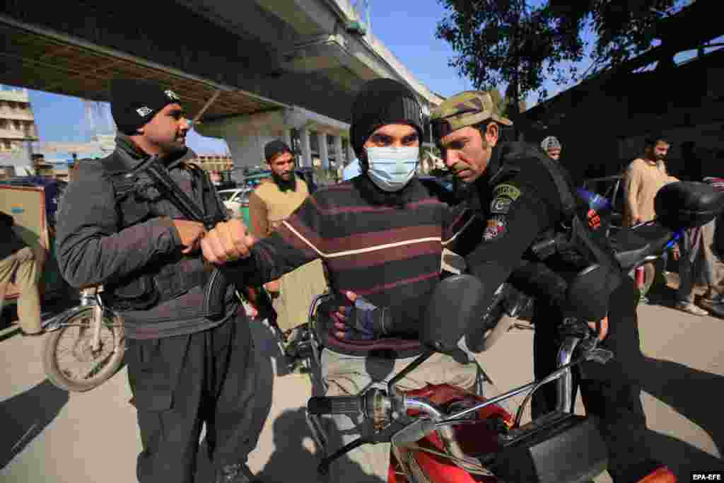 Pakistani security officials in Peshawar conduct inspections at a checkpoint amid a high-security alert in the country, which has seen a spike in violent incidents since the Taliban takeover of neighboring Afghanistan.&nbsp;