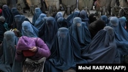 Disa gra me burka duke pritur para një furre në Kabul. Janar 2022.