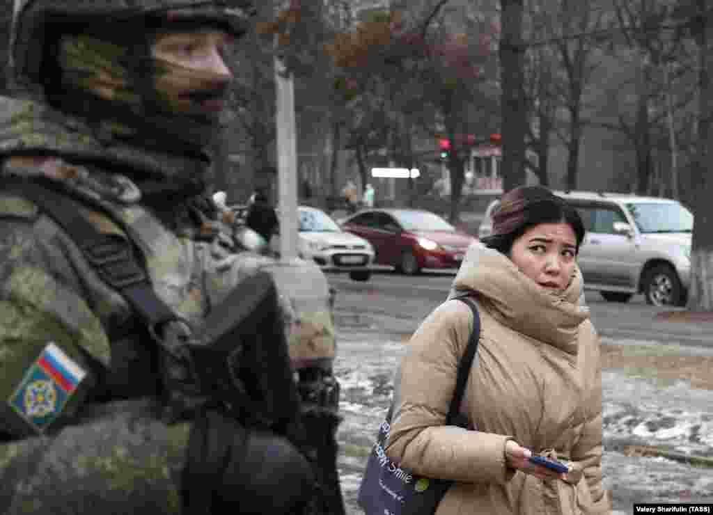 A woman glances at a Russian CSTO peacekeeper in Almaty on January 11.&nbsp;