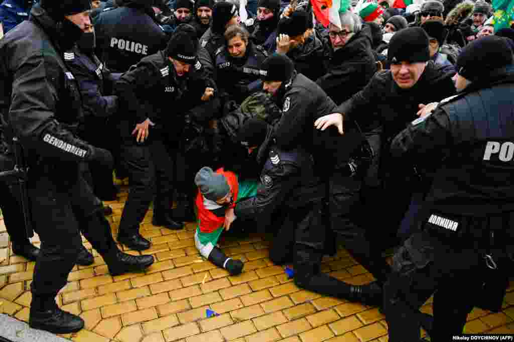 Bulgarian protesters clash with police officers as they try to enter the parliament building during a demonstration against anti-coronivirus measures in Sofia on January 12.&nbsp;
