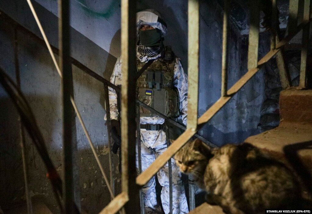 Një ushtar ukrainas dhe një mace duke qëndruar më 25 janar në një strehë në vijën e frontit, jo shumë larg Donetskut, që kontrollohet nga separatistët e mbështetur nga Rusia, teksa po rritet frika për një pushtim të Ukrainës nga Rusia.